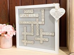 a family scrabble frame with a heart hanging on the wall next to it