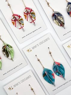 several different earrings are displayed on cards