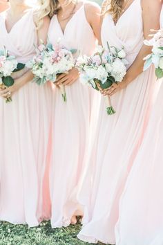 the bridesmaids are wearing pink dresses and holding bouquets in their hands together