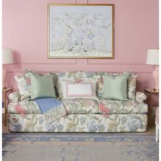 a living room with pink walls and floral furniture