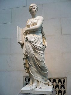 a statue of a woman holding a book