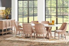 a dining room table and chairs in front of large windows