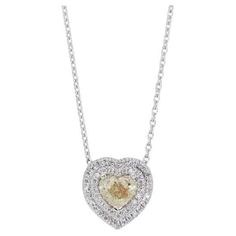 This exquisite necklace isn't just an accessory; it's a captivating story told in diamonds. At its heart, nestled in 18K white gold polished to a high shine, lies a magnificent 0.88-carat heart-shaped diamond. Its fancy yellow color evokes the warmth of sunlight on autumn leaves, radiating a unique and playful elegance. But the story doesn't end there. This heart finds solace and sparkle among 16 round brilliant side stones, totaling 0.24 carats, showcasing a symphony of colors from colorless (COL) to near-colorless (F-G). Each diamond, accented by VS and VG clarity and cut grades, plays its part in amplifying the brilliance of the central gem. The love story continues: 12 more tiny diamonds, totaling 0.03 carats, whisper secrets of romance with their near-colorless (F-G) hues and VS clari Heart Diamond Necklace, Heart Necklace Diamond, Yellow Heart, Heart Diamond, Tiny Diamond, Heart Shaped Diamond, Gold Polish, Diamond Heart, Yellow Color