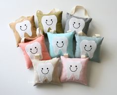 four pillows with different designs on them and one has a smiling tooth in the middle