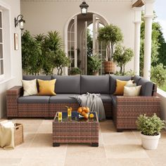 an outdoor living area with couches, tables and potted plants on the patio