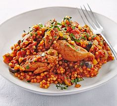 a white plate topped with meat and beans