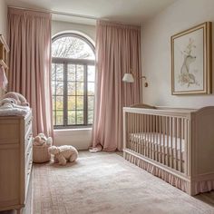 a baby's room with pink drapes and curtains