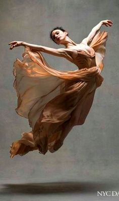 a woman in a flowing dress is dancing