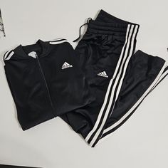 Women's Adidas Essentials 3-Stripes Track Suit - New With Tags Color: Black & White Drawstring Elastic Waist Cuffed Sleeve 2 Zipper Pockets (Jacket) 2 Front Pockets This Adidas Tracksuit Has A Regular Fit That Feels Timeless, Along With Unmistakable Adidas 3-Stripes Down Both The Sleeves And Legs. The Jacket Has A Full Zip Up The Front, Making It A Breeze To Layer For A Busy Day On The Go, No Matter What Happens With The Weather. This Product Is Made With Primegreen, A Series Of High-Performance Adidas Long Sleeve Track Jacket With Three Stripes, Black Adidas Track Jacket, Functional Adidas Black Track Jacket, Adidas Black Sports Track Jacket, Women’s Adidas Tracksuit, Adidas Set, Adidas Tracksuit, Cuffed Sleeve, No Matter What Happens