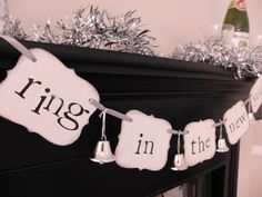 a decorated mantle with silver tinsel garland and decorations on it that says sing in the rain