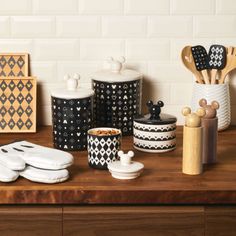 kitchen utensils are arranged on a wooden counter