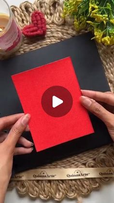 two hands holding an open book with a video on it