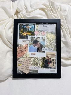 a collage of photos is displayed in a black frame on a white bed sheet