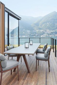 a table and chairs on a deck overlooking the water