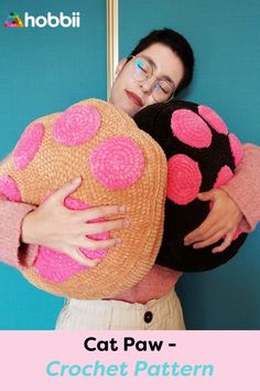 a woman is holding a cat pillow in front of her face and the caption reads, cat paw - crochet pattern