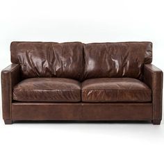 a brown leather couch sitting on top of a white floor