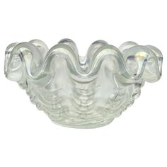 a glass bowl that is sitting on top of a white surface with swirly shapes