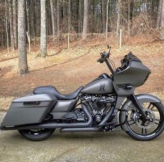 a black motorcycle parked in front of some trees