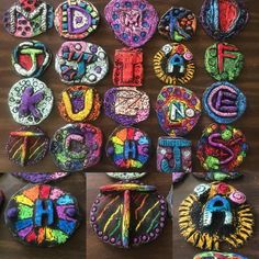 many different types of buttons on a wooden table with letters and numbers painted on them