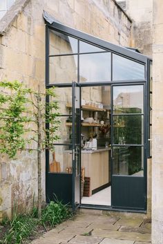 an open door to a kitchen with lots of glass on the front and side of it