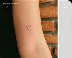 a small bird tattoo on the left arm and an image of a woman's arm