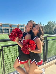 two girls in cheerleader outfits posing for the camera