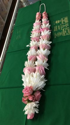 pink and white flowers are arranged on a green table cloth in the shape of a flower