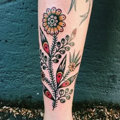 a woman's leg with tattoos and flowers on it