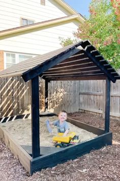 a little boy playing in his sandbox