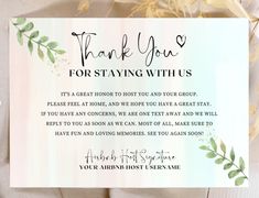 thank you for staying with us card on top of a white table cloth next to flowers and greenery