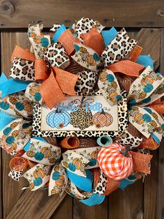 a wreath made out of fabric and ribbon on a wooden fence with an animal theme