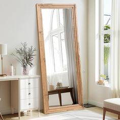 a large mirror sitting in the middle of a room next to a table and chair