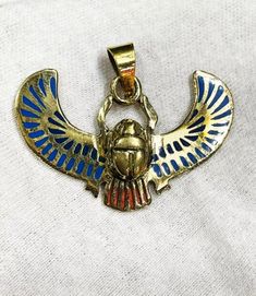 your beautiful Egyptian Amulet of the Egyptian Royal Winged Scarab, hand made from Brass with amazing Gold plated 18k karat and inlaid with the natural gemstones with the beautiful Egyptian details like the original one, You can also use it as a small antique, specially made for you ;) ONE OF A KIND PIECE!! The Royal Gold Plated Winged Scarab, Pendant for Necklace The Egyptian scarab was closely connected with the sun god Khepri, who brought the sunrise over the horizon each day. Thus, it became Handmade Medallion Jewelry For Good Luck, Symbolic Multicolor Festival Jewelry, Bronze Pendant Jewelry For Blessings, Symbolic Handmade Jewelry For Rituals, Handmade Symbolic Jewelry, Handmade Symbolic Jewelry For Blessing, Handmade Rituals Pendant Jewelry, Symbolic Multicolor Pendant Jewelry, Handmade Symbolic Multicolor Jewelry