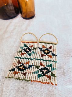 two beaded earrings sitting on top of a table