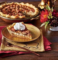 a slice of pecan pie with whipped cream on top sits on a gold plate