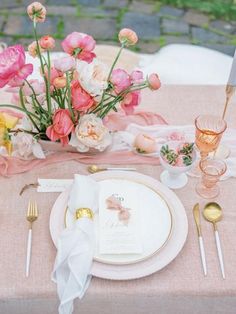 the table is set with pink and white flowers