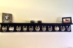 there is a shelf that has many glasses on it and two pictures hanging above the shelves