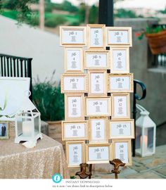 a table topped with lots of pictures next to a white and gold wedding cake topper