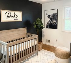 a baby's room with black walls and white rugs, wooden crib