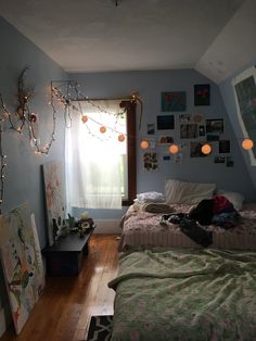 two beds in a room with lights strung from the ceiling and pictures on the wall