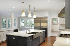 a kitchen with an island, sink and refrigerator in it's center area is shown