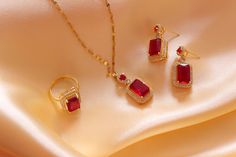 Introducing our exquisite Luxury Red Zircon Jewelry Set, a dazzling collection of meticulously crafted pieces designed to add a touch of elegance and sophistication to your style. This set includes a stunning Gemstone Pendant, Sapphire Ring, Necklace, and Earrings, making it the perfect choice for brides, engagements, or any special occasion. Features: 1. Red Zircon Gemstone Pendant: A brilliant red zircon gemstone is the focal point of this exquisite pendant. Crafted with precision and care, the pendant showcases the deep, rich hue of the red zircon. The pendant is elegantly set in a high-quality metal setting, adding to its allure. 2. Red Zircon Sapphire Ring: This dazzling ring features a radiant red zircon gemstone, accented by shimmering sapphire stones. The unique design and meticulo Red Ruby Jewelry Gift For Her, Red Gemstone Jewelry As Gift For Her, Red Gemstone Jewelry Gift For Her, Red Fine Jewelry As A Gift For Her, Red Gold-plated Jewelry Set For Wedding, Ruby Jewelry With Earrings For Valentine's Day, Valentine's Day Ruby Jewelry With Matching Earrings, Dazzling Gold Plated Jewelry Sets Gift, Ruby Jewelry With Matching Earrings For Gift