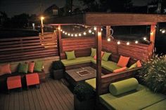 an outdoor seating area is lit up with string lights