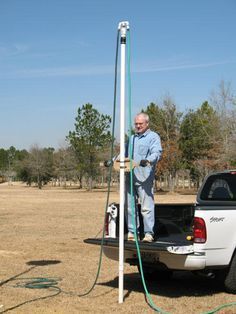 a man standing in the back of a truck with a water hose attached to it