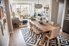 a dining room table with chairs and a rug on the floor