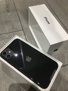 an apple iphone in its box on the floor next to it's new packaging