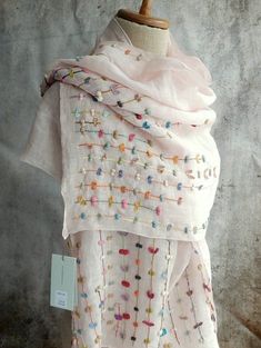 a white scarf with multicolored beads on it