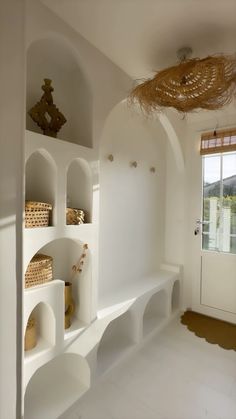 a white room with shelves and baskets on the wall