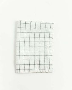 a white and green checkered napkin on a white surface with a black line in the middle