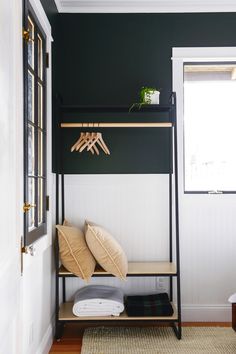 a bedroom with black walls and white trim on the wall, an iron bed frame holds two pillows